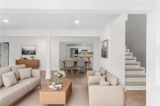 living room with light wood finished floors, stairway, and recessed lighting