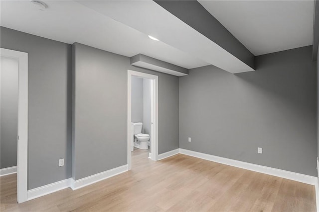 finished basement with baseboards and light wood-style floors