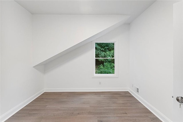 additional living space featuring visible vents, baseboards, and wood finished floors