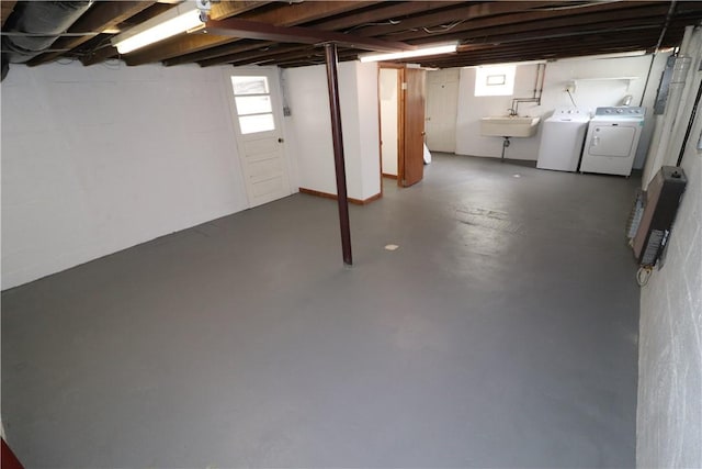 basement with washing machine and dryer, a healthy amount of sunlight, and a sink