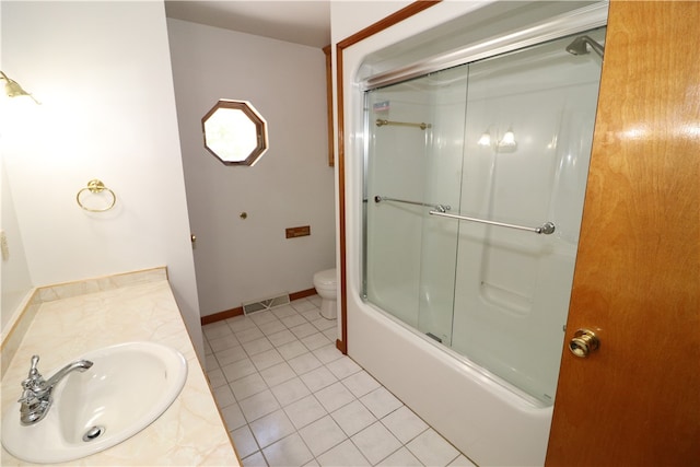 full bathroom featuring vanity, tile patterned floors, shower / bath combination with glass door, and toilet