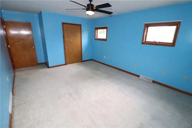 unfurnished bedroom with baseboards, visible vents, light colored carpet, ceiling fan, and a closet