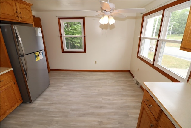 kitchen featuring ceiling fan, stainless steel refrigerator, and light hardwood / wood-style floors