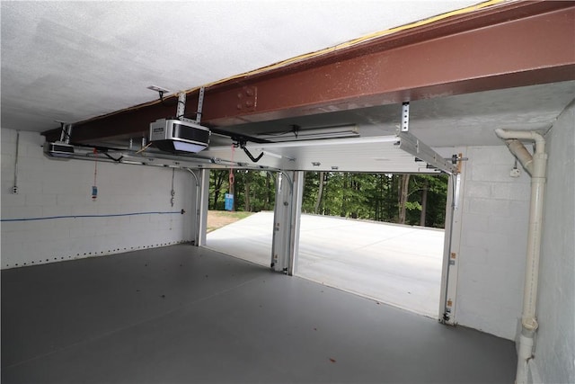 garage with concrete block wall and a garage door opener