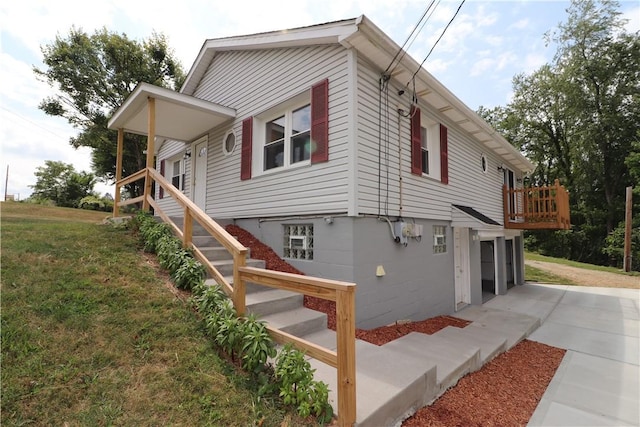 view of side of home featuring concrete driveway and a yard