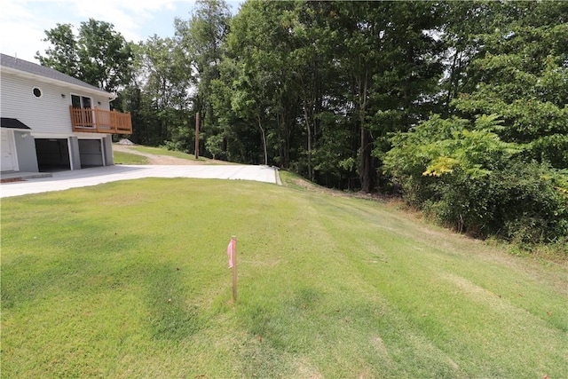 view of yard with a garage, driveway, and a deck