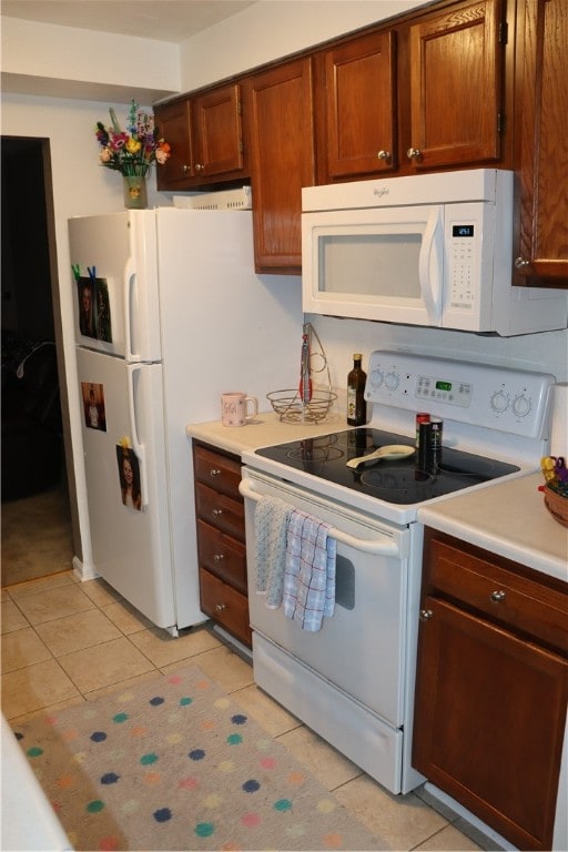 kitchen featuring light tile patterned flooring and white appliances