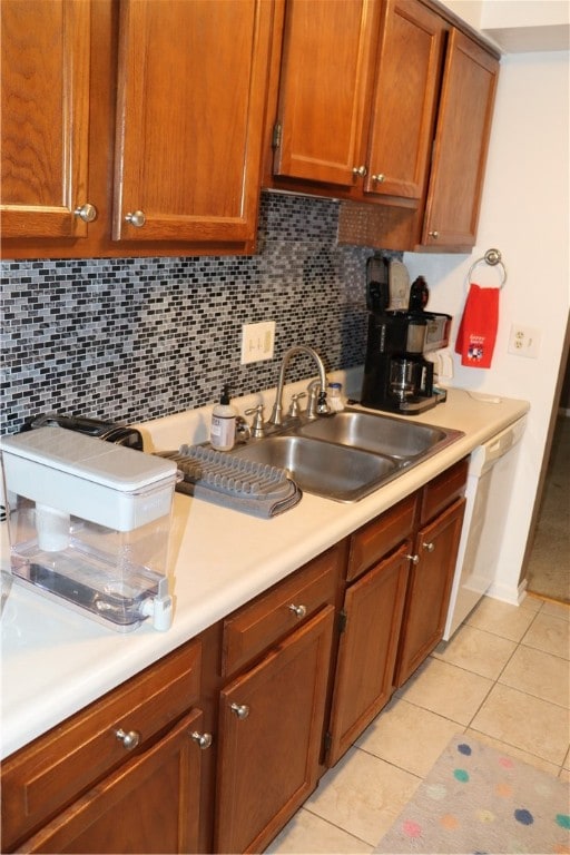 kitchen featuring dishwasher, tasteful backsplash, sink, and light tile patterned floors