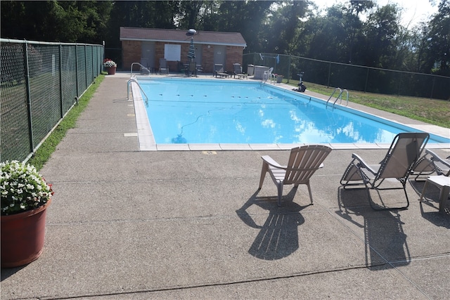 view of pool with a patio and an outbuilding