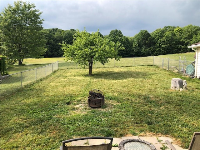 view of yard with an outdoor fire pit and a rural view