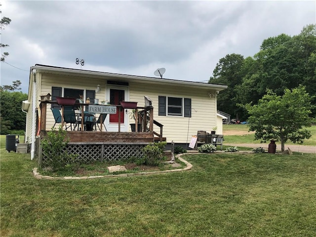 rear view of house featuring a deck, a lawn, and central air condition unit