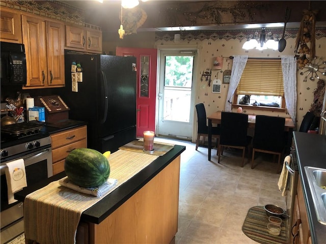 kitchen featuring decorative light fixtures, sink, light tile patterned floors, black appliances, and an inviting chandelier