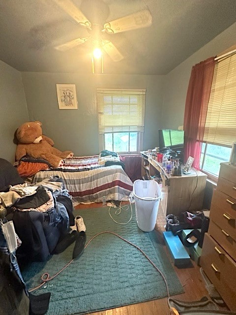 bedroom with hardwood / wood-style flooring, multiple windows, and ceiling fan