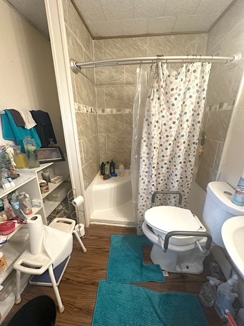 bathroom featuring walk in shower, hardwood / wood-style floors, and toilet