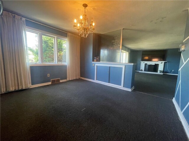 unfurnished living room featuring an inviting chandelier and carpet flooring