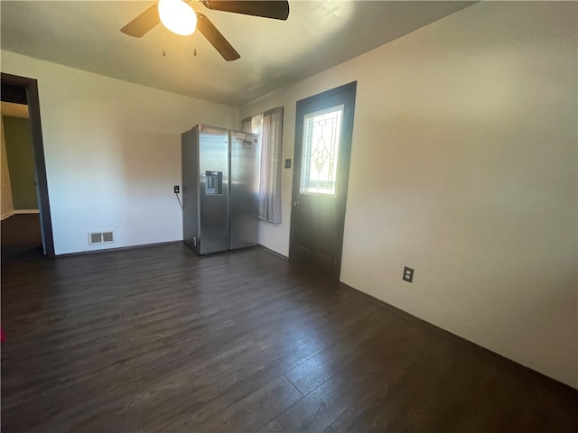 spare room with dark wood-type flooring and ceiling fan