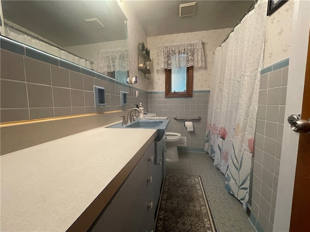 bathroom featuring toilet, vanity, tile walls, tile patterned floors, and decorative backsplash