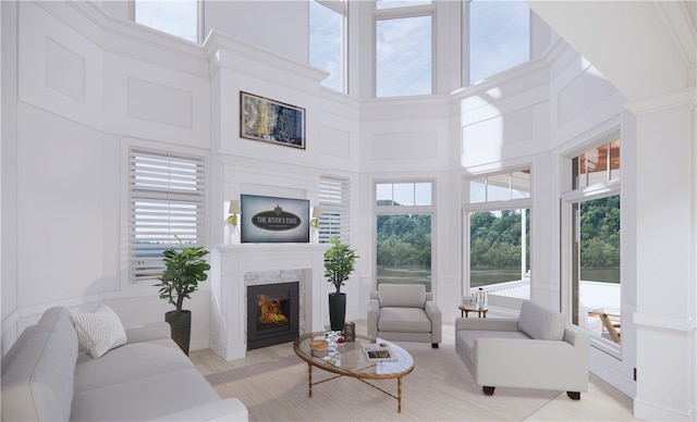 living room with a fireplace and a towering ceiling