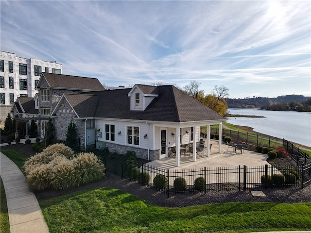 rear view of house featuring a water view and a patio