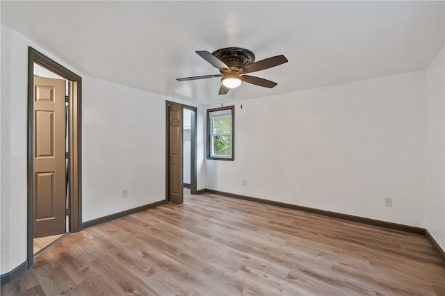 spare room with light wood-type flooring and ceiling fan