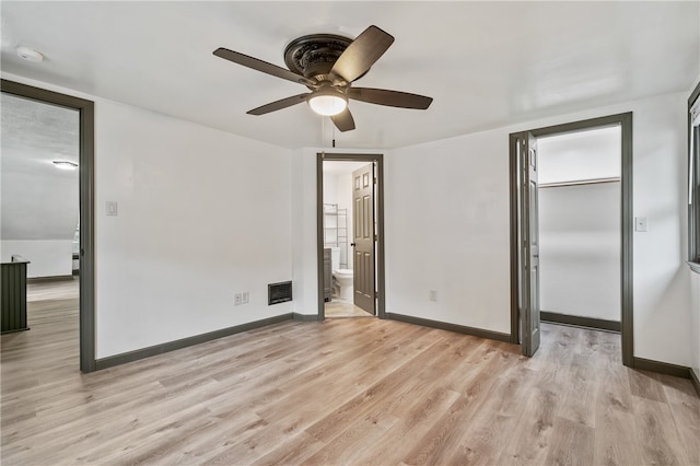 unfurnished bedroom featuring light hardwood / wood-style floors, ensuite bathroom, ceiling fan, and a closet