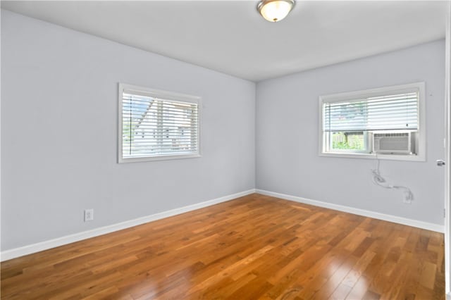 empty room featuring cooling unit and hardwood / wood-style floors