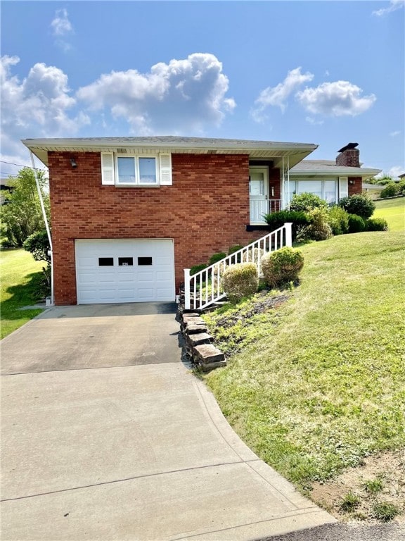 142 Greenridge Dr, Carroll Twp, PA 15063 - view of side of property with concrete driveway, a yard, a garage, and brick siding