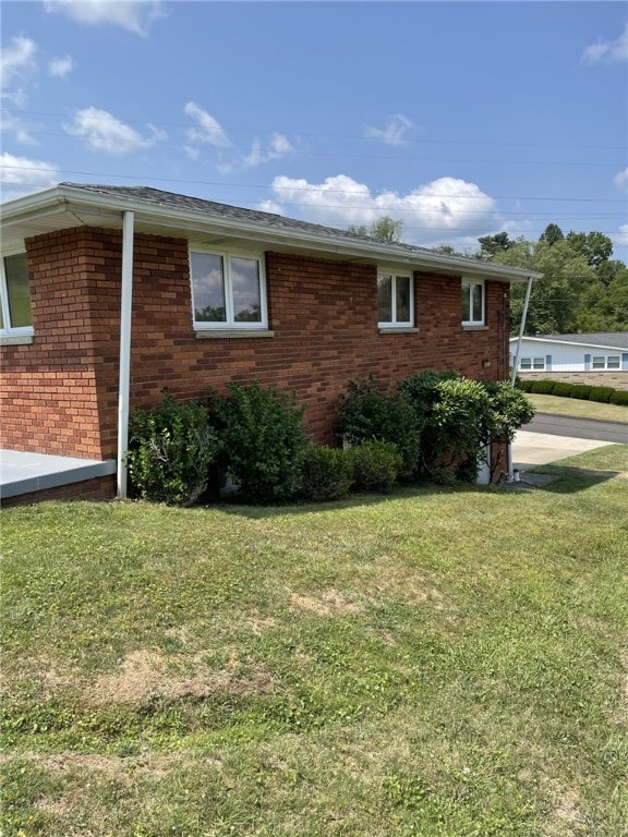 142 Greenridge Dr, Carroll Twp, PA 15063 - view of side of home featuring a lawn and brick siding