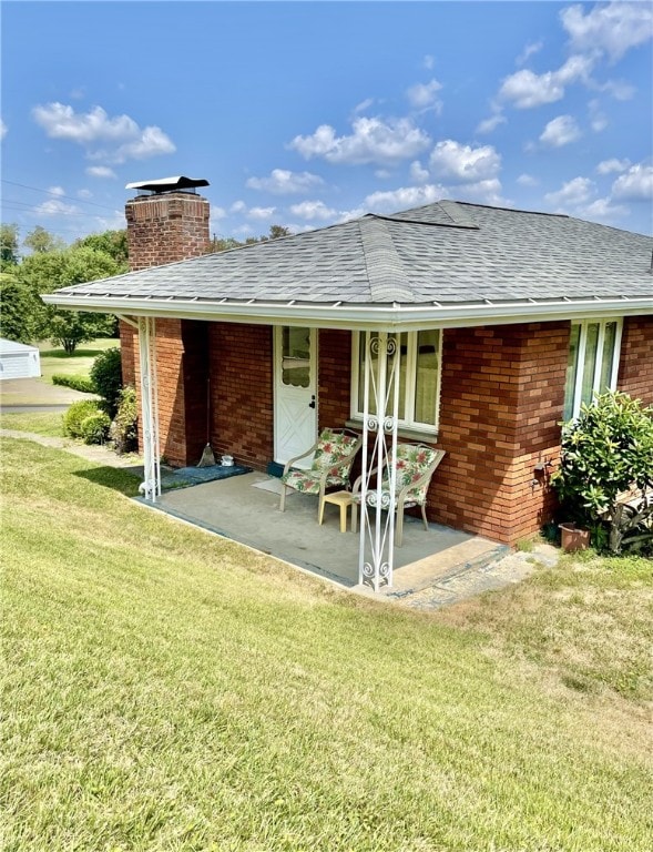 142 Greenridge Dr, Carroll Twp, PA 15063 - back of property featuring roof with shingles, a chimney, a yard, and a porch