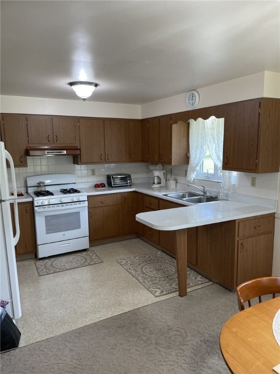 kitchen featuring sink, decorative backsplash, and white appliances