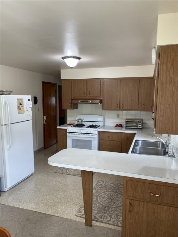 142 Greenridge Dr, Carroll Twp, PA 15063 - kitchen featuring white appliances, a sink, under cabinet range hood, light countertops, and a peninsula