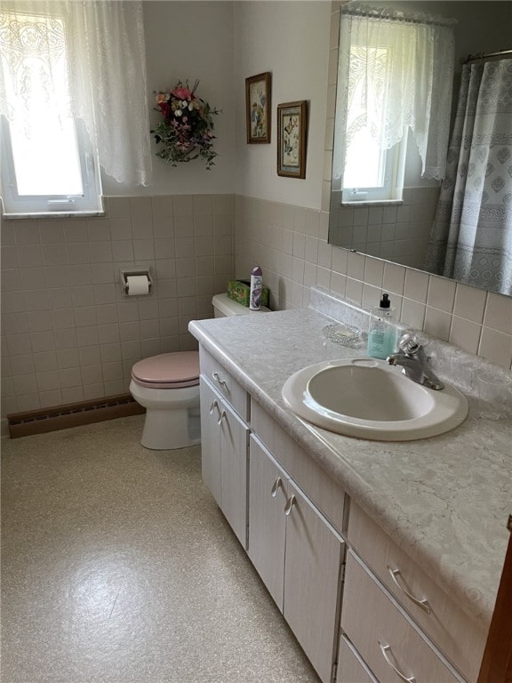 bathroom with plenty of natural light, decorative backsplash, and tile walls