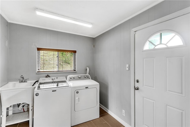 laundry area with dark hardwood / wood-style floors, wooden walls, sink, crown molding, and washer and dryer