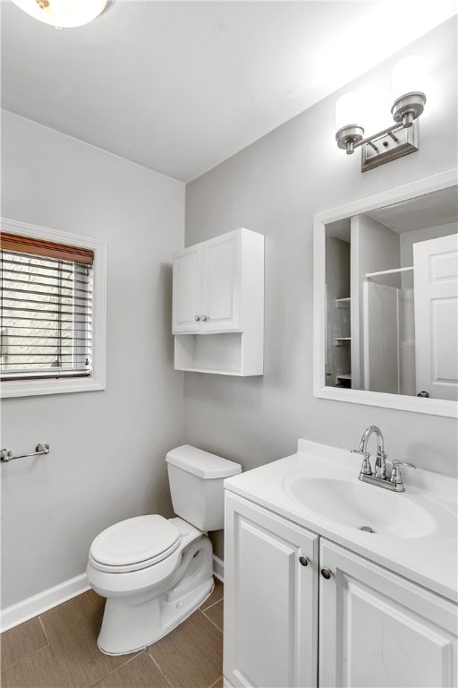 bathroom featuring toilet, walk in shower, and vanity