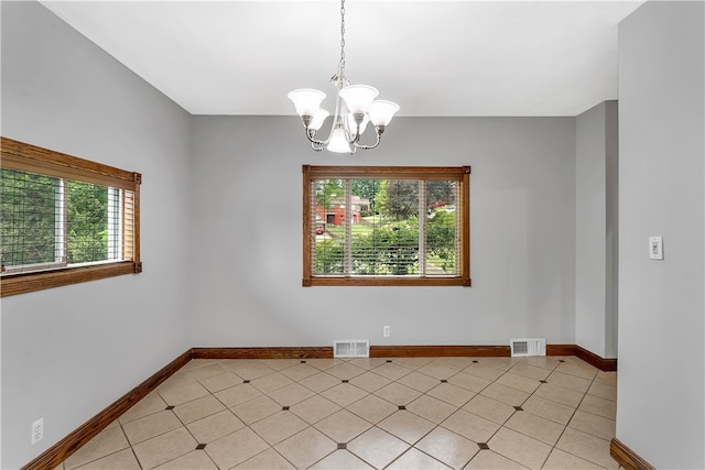 spare room featuring a chandelier