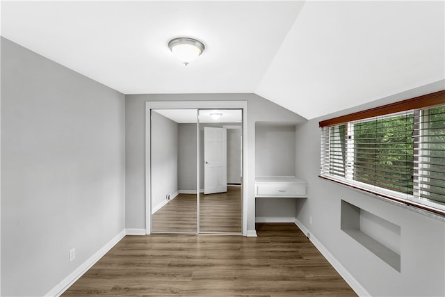 interior space featuring a closet, dark wood-type flooring, and lofted ceiling