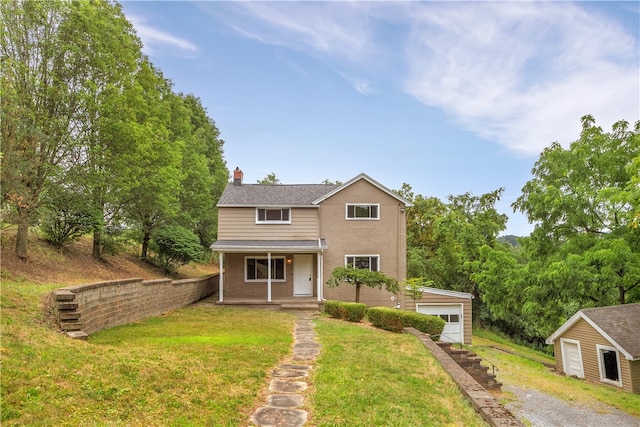 view of front of property featuring an outdoor structure, a garage, and a front lawn