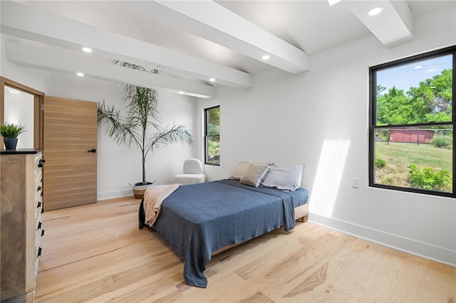 bedroom featuring beam ceiling and light hardwood / wood-style flooring