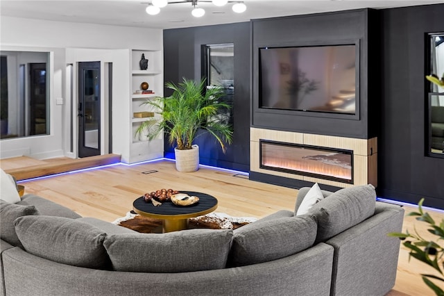 living room featuring hardwood / wood-style flooring and built in shelves