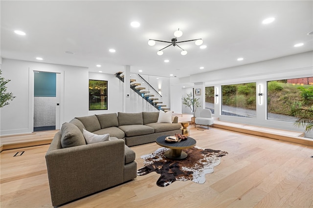 living room with a chandelier and light wood-type flooring