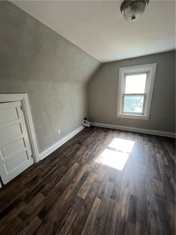 additional living space with vaulted ceiling and dark hardwood / wood-style floors