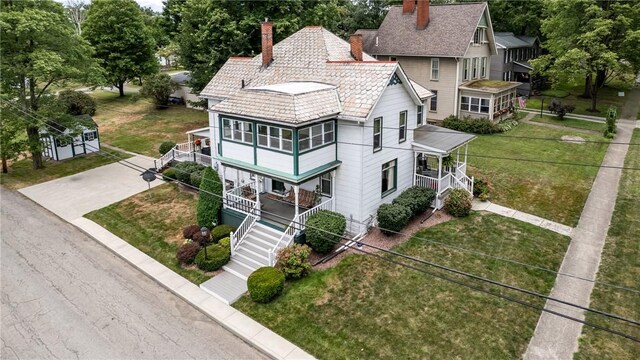 exterior space with covered porch and a lawn