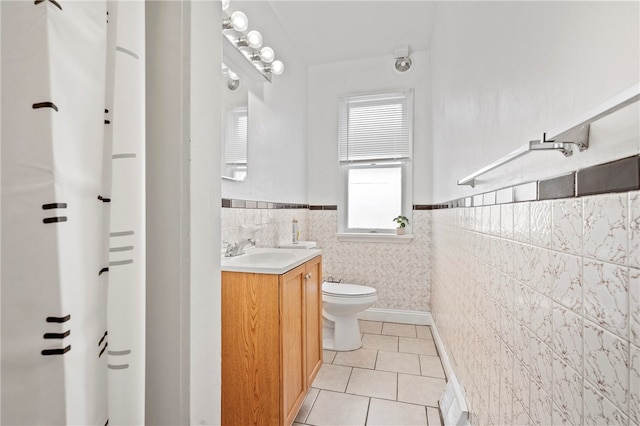 bathroom with tile patterned floors, vanity, tile walls, and toilet