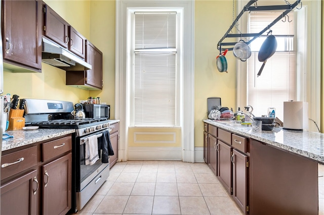 kitchen featuring appliances with stainless steel finishes, light stone counters, and light tile patterned floors