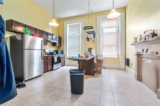 kitchen with light tile patterned flooring, a kitchen island, pendant lighting, and stainless steel appliances