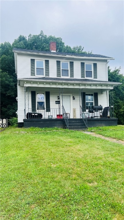 view of front of house with covered porch and a front lawn