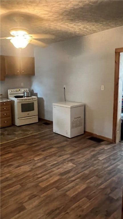 kitchen with electric stove, dark wood-type flooring, and refrigerator