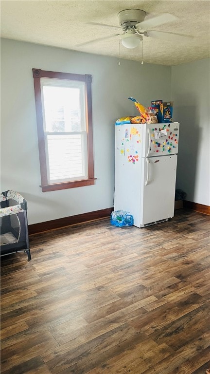 interior space with a textured ceiling, ceiling fan, wood-type flooring, and white refrigerator