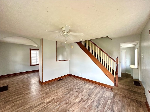 118 Wengler Ave, Sharon, PA 16146 - unfurnished living room with visible vents, a ceiling fan, arched walkways, and wood finished floors