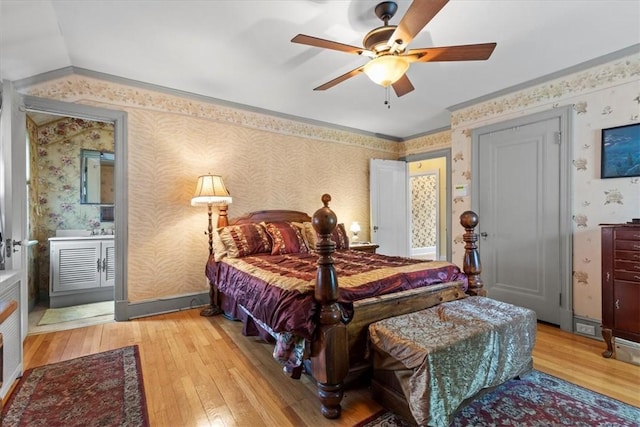 bedroom featuring light wood-style floors, a ceiling fan, ornamental molding, baseboards, and wallpapered walls